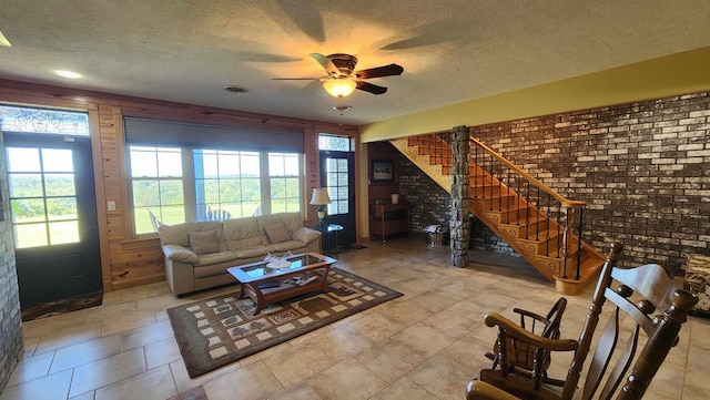 living room with stairs, a textured ceiling, visible vents, and a healthy amount of sunlight