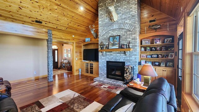 living room featuring wood ceiling, wooden walls, a fireplace, and wood finished floors