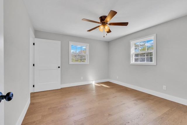 spare room with a healthy amount of sunlight, light wood-style floors, and baseboards