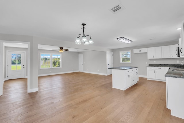 kitchen with light wood finished floors, visible vents, white cabinetry, pendant lighting, and a wealth of natural light