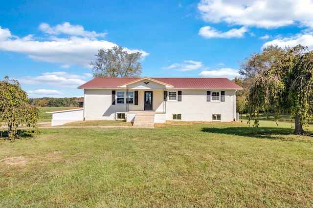 single story home with metal roof, brick siding, and a front yard