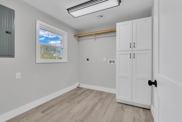 laundry area featuring cabinet space, electric panel, baseboards, hookup for an electric dryer, and light wood-style floors