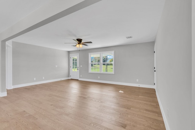 empty room with light wood-style flooring, visible vents, baseboards, and a ceiling fan