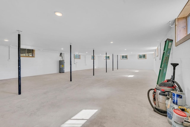 basement featuring electric water heater and recessed lighting