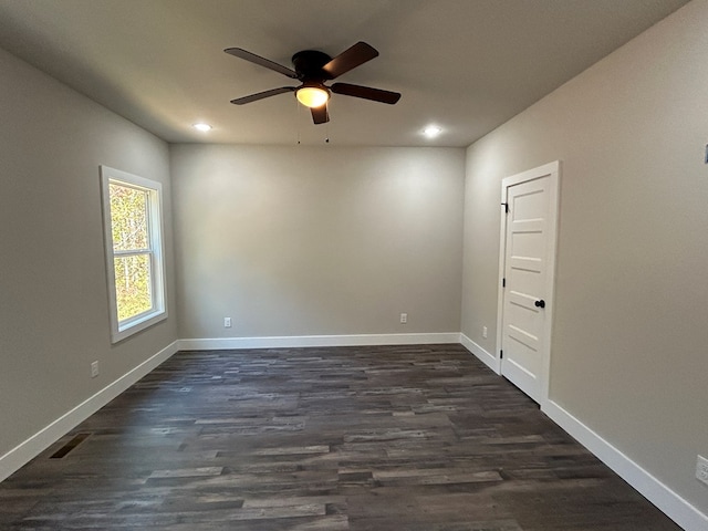 spare room featuring dark wood-type flooring, recessed lighting, visible vents, and baseboards