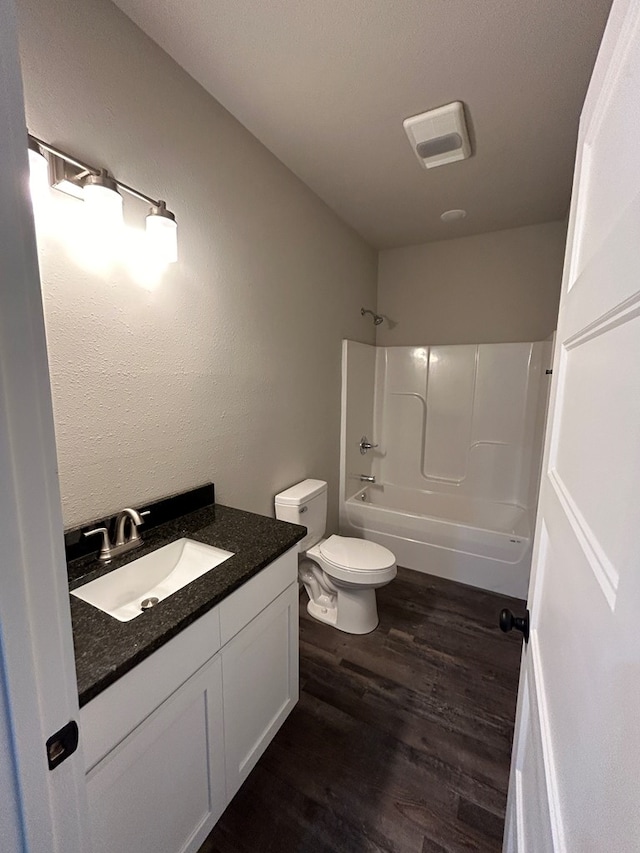 full bath featuring tub / shower combination, vanity, toilet, and wood finished floors