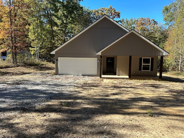 chalet / cabin with a garage and dirt driveway