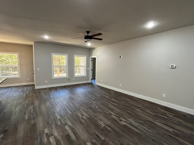 interior space with dark wood-style floors, ceiling fan, and baseboards