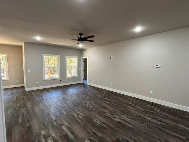 unfurnished room with dark wood-style floors, baseboards, and a ceiling fan