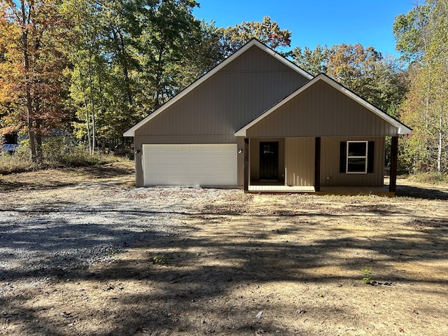 rustic home featuring an attached garage and dirt driveway