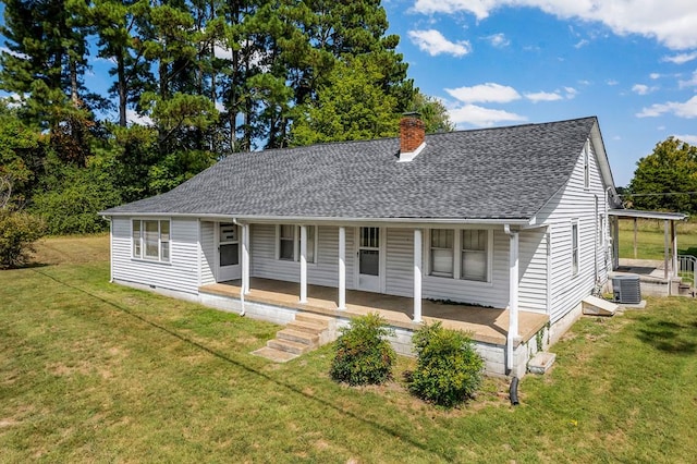 view of front of home with a shingled roof, covered porch, a chimney, and a front lawn