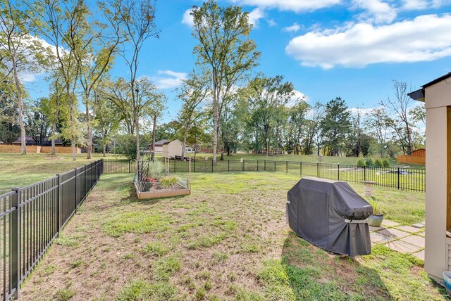 view of yard featuring a fenced backyard, a vegetable garden, and a rural view