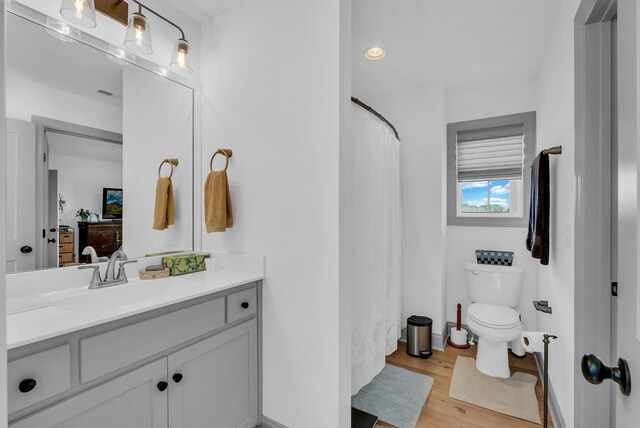 full bathroom featuring ensuite bathroom, wood finished floors, vanity, and toilet