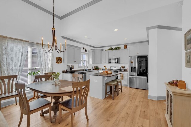 dining room with light wood finished floors, baseboards, ornamental molding, a notable chandelier, and recessed lighting