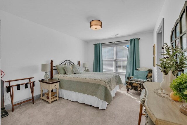 bedroom featuring visible vents and light colored carpet