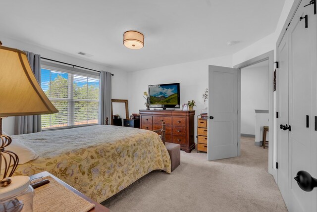 bedroom featuring visible vents, a closet, and light colored carpet