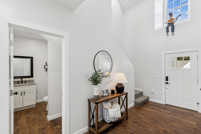 foyer with dark wood-style floors, stairs, and baseboards