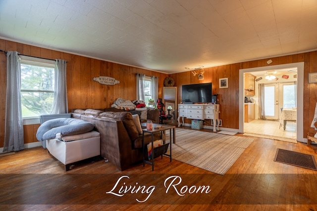 living area with wood finished floors and wooden walls