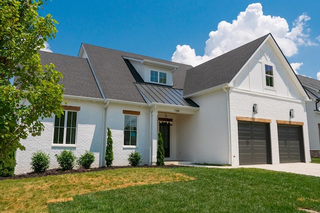 modern farmhouse style home with driveway, a standing seam roof, an attached garage, a front lawn, and metal roof