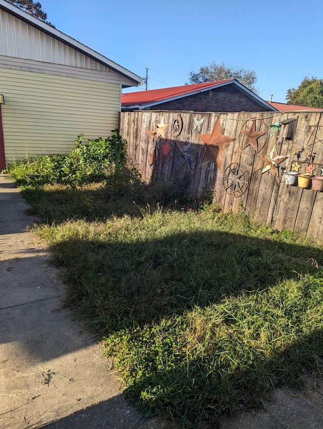 exterior space with fence and a lawn