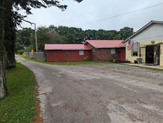 exterior space featuring metal roof and driveway