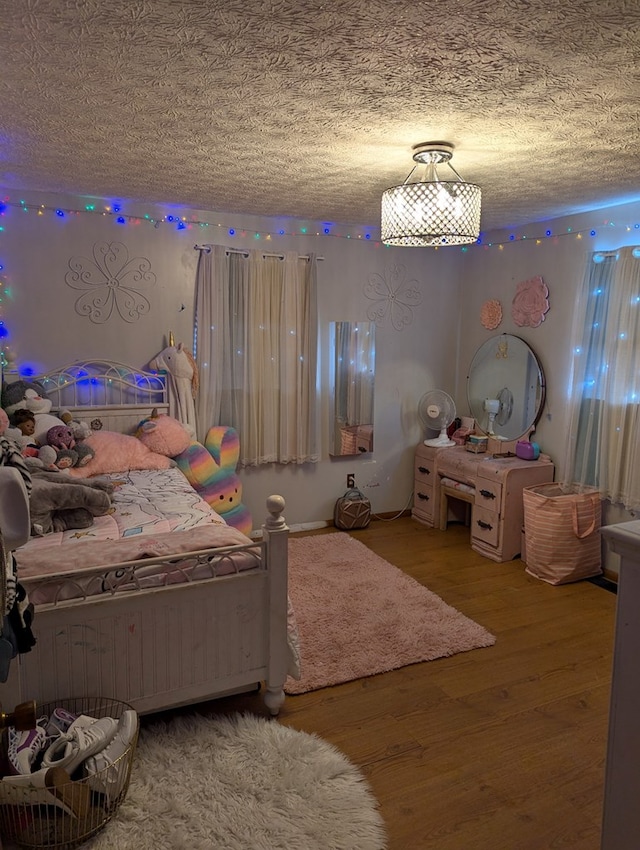 bedroom with a textured ceiling and wood finished floors