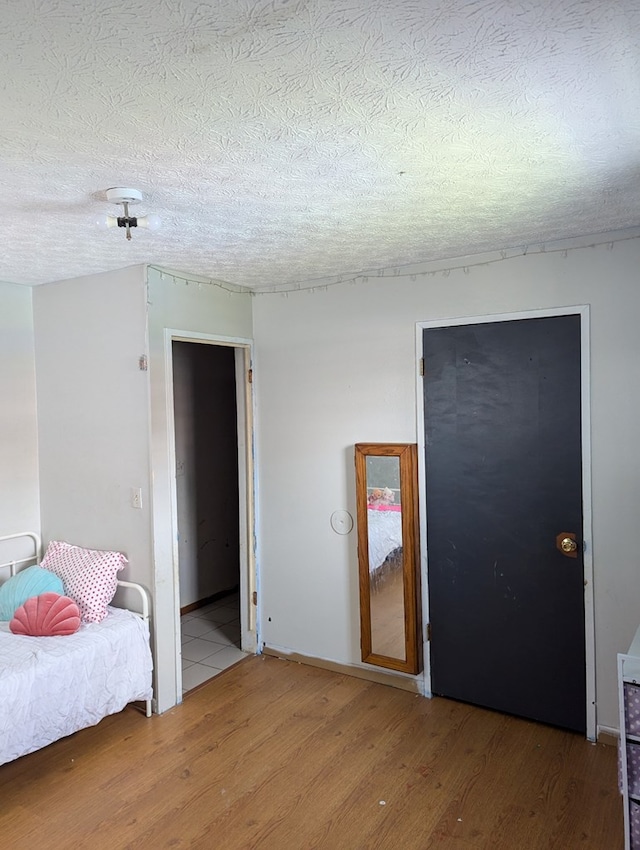 bedroom featuring a textured ceiling and wood finished floors