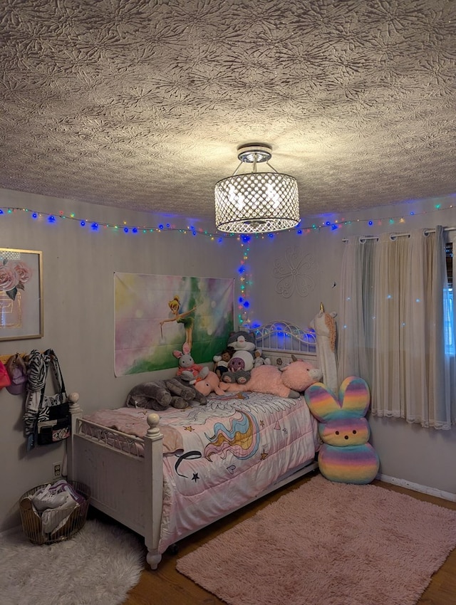 bedroom featuring a textured ceiling and wood finished floors