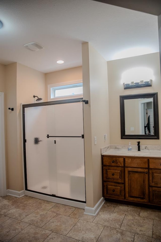 full bath featuring a stall shower, vanity, and baseboards