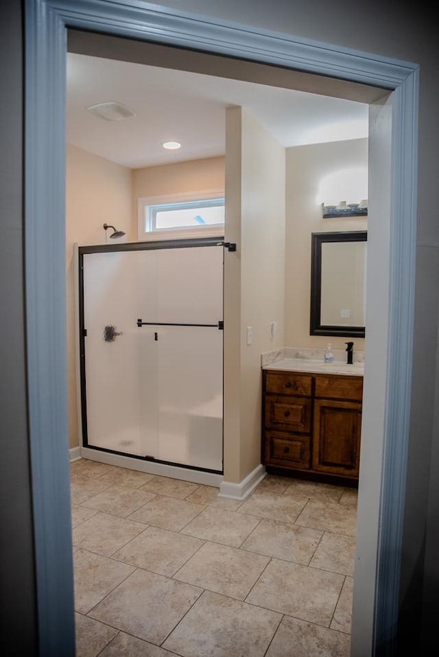 full bathroom featuring baseboards, a shower stall, vanity, and tile patterned floors