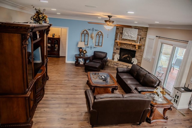 living area with light wood-style flooring, recessed lighting, a fireplace, a ceiling fan, and crown molding