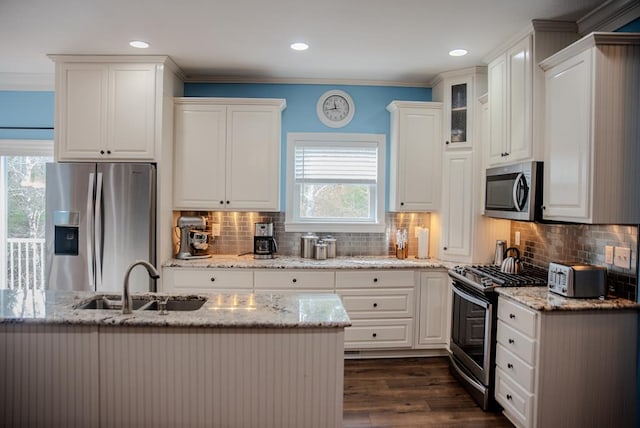 kitchen featuring glass insert cabinets, appliances with stainless steel finishes, white cabinets, and a sink