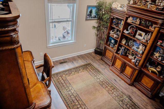 interior space featuring light wood-style floors, visible vents, and baseboards