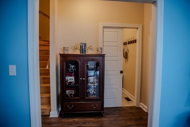 interior space featuring dark wood-style flooring, visible vents, and baseboards