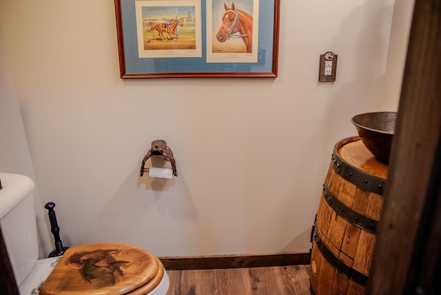 bathroom featuring baseboards, toilet, and wood finished floors