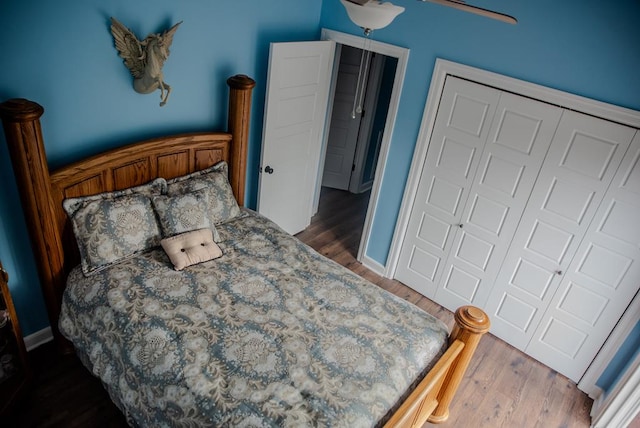 bedroom with a closet, baseboards, and dark wood-type flooring