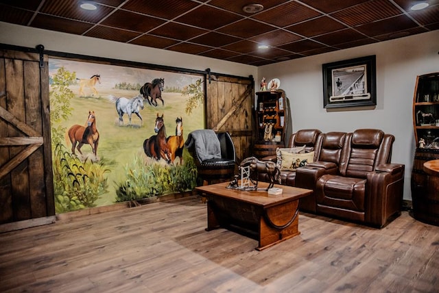 living area featuring a barn door and wood finished floors