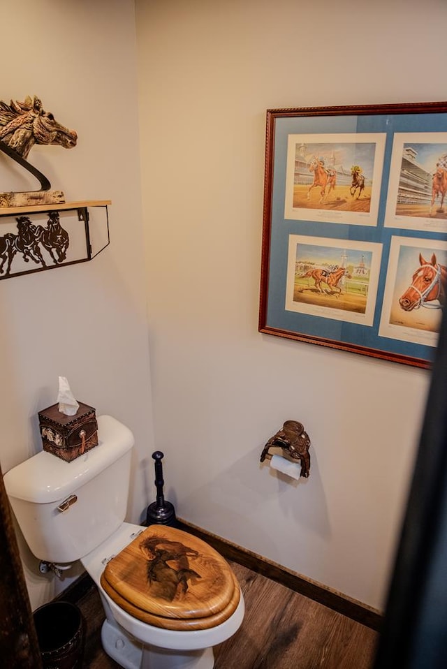 bathroom featuring toilet, baseboards, and wood finished floors