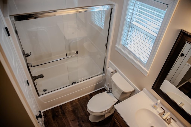 full bath with toilet, enclosed tub / shower combo, wood finished floors, and vanity