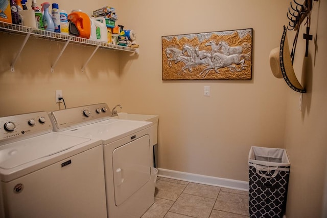 laundry area with laundry area, light tile patterned floors, baseboards, and washer and dryer