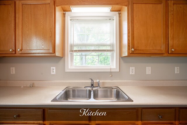 kitchen with brown cabinets, light countertops, and a sink