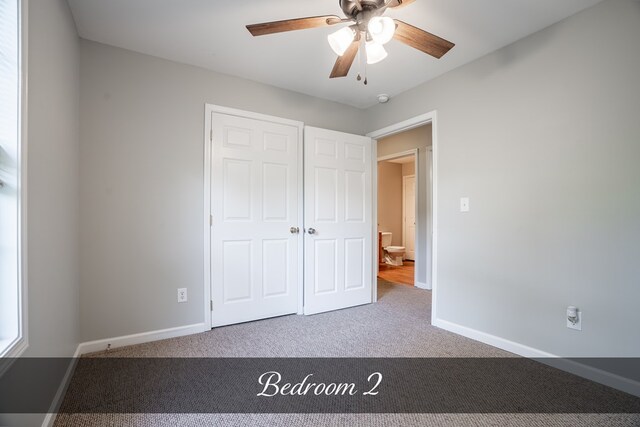 unfurnished bedroom with carpet, baseboards, ceiling fan, and a closet