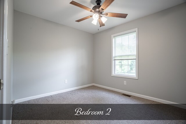 spare room featuring ceiling fan, carpet, visible vents, and baseboards