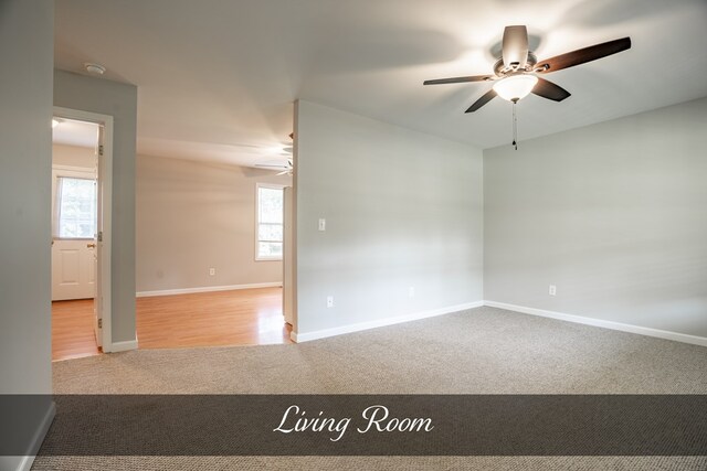 spare room with baseboards, a ceiling fan, and light colored carpet