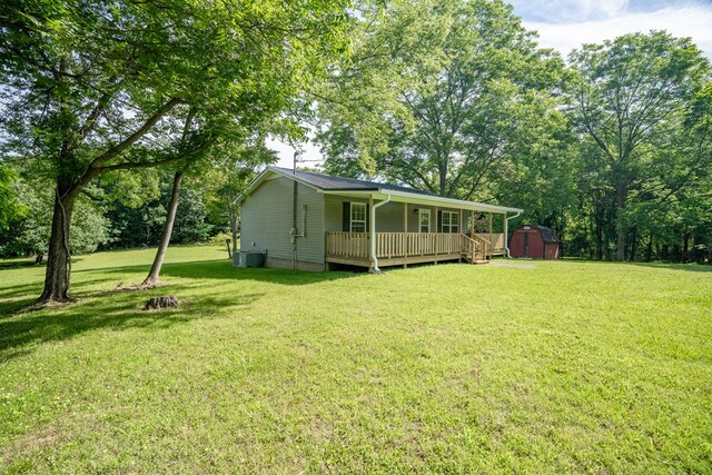 view of yard featuring covered porch, an outdoor structure, and a shed