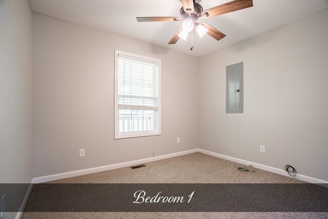 carpeted spare room with a ceiling fan, electric panel, visible vents, and baseboards