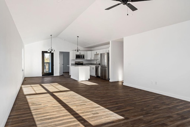 kitchen with a kitchen island, appliances with stainless steel finishes, open floor plan, hanging light fixtures, and white cabinetry