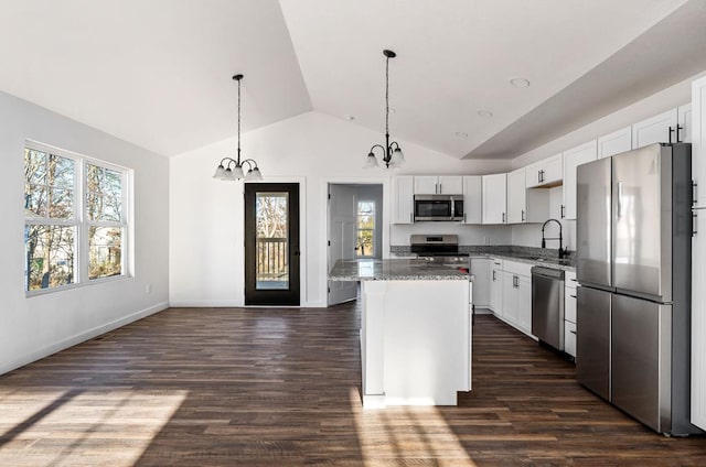 kitchen with a kitchen island, white cabinetry, stainless steel appliances, and a sink