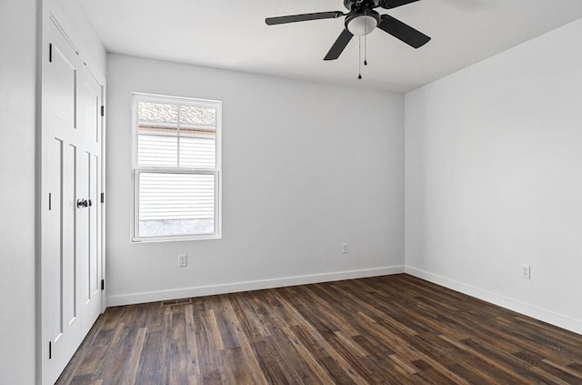 unfurnished bedroom with ceiling fan, baseboards, and dark wood-type flooring