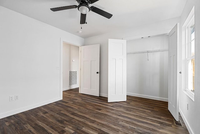 unfurnished bedroom with visible vents, baseboards, a ceiling fan, dark wood finished floors, and a closet